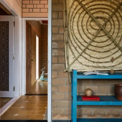 In our EESHA residence project, we used Compressed Stabilized Earth Blocks (CSEB) for the walls. These unburnt mud bricks provide excellent thermal insulation and are a core part of our sustainable building practice. The doorway shown here features a repurposed frame salvaged from a demolished home, giving a new life to old materials.