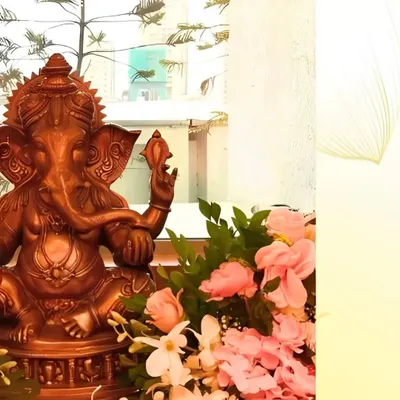We create a divine atmosphere for Lord Ganesha with elegant floral pairings. Here, a beautiful bronze Ganpati idol is surrounded by a delicate arrangement of soft pink roses and white orchids, creating a feeling of peace and devotion.