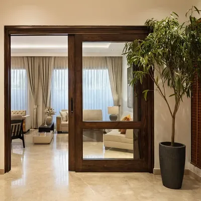 The journey into Terra begins with a moment of pause. The foyer, with its serene Pichwai painting and sliding wood-and-glass door, sets a tone of calm energy, filtering light and framing the view into the living space beyond.