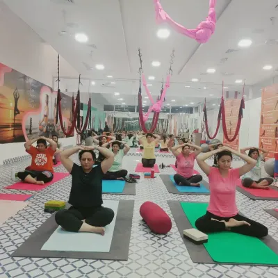 A group of students practicing pranayama (yogic breathing). This practice is fundamental for calming the nervous system, improving focus, and preparing the body and mind for meditation.