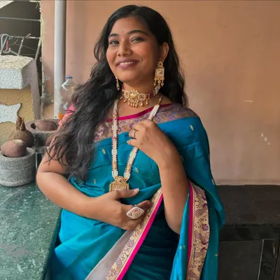 This is a beautiful fusion look, pairing a traditional Paithani saree with a modern Meenakari choker and long necklace set for a unique style statement.