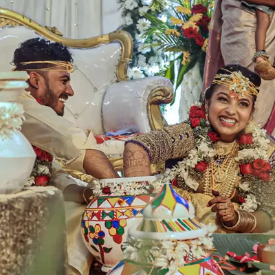 Capturing the fun and laughter of traditional wedding games. This candid shot shows the couple's playful interaction, a memory they will surely cherish. These moments add so much personality to a wedding album.
