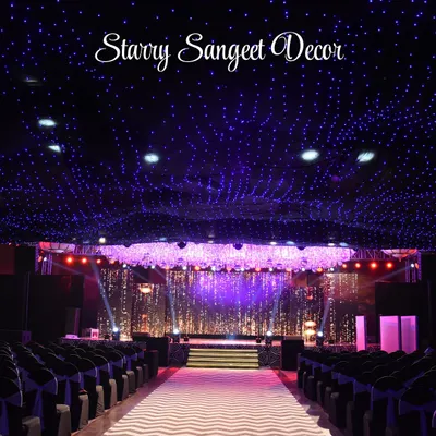 A ceiling of twinkling fairy lights creates a 'starry night' effect for this Sangeet. This immersive lighting design transforms the entire ballroom into a magical, celestial space for a night of dancing and celebration.