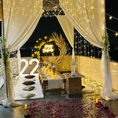 A full view of a birthday cabana on a rooftop, complete with sheer curtains, fairy lights, and a candlelit dinner table. This shows how I can create a private, romantic world for your special occasion.