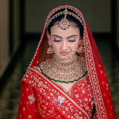 A portrait of bridal elegance. The focus on the intricate jewelry and serene expression captures the moments of quiet anticipation before the ceremony.