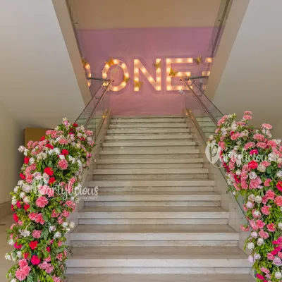 An entrance should make a statement. For this event, I transformed a simple staircase into a grand floral walkway, leading guests upstairs to the main event with a beautiful marquee sign that set a celebratory tone.