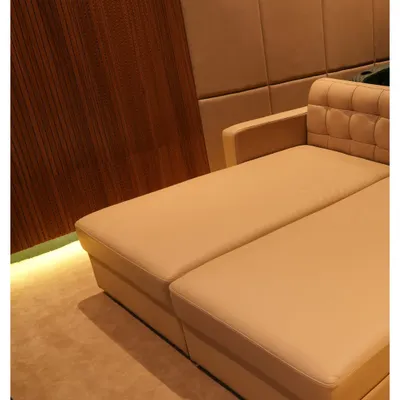 A close-up of a custom-designed daybed in a Nellore project, showing the combination of plush upholstery and elegant wood paneling with subtle floor lighting.