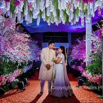 This engagement portrait uses the magnificent floral decor to create a grand, fairytale-like setting. The dramatic lighting makes the couple stand out beautifully.