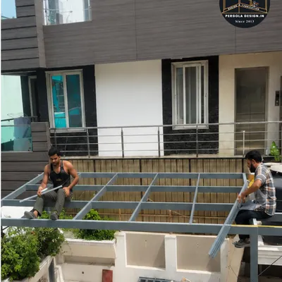 This image captures our team during the crucial framework installation phase. It shows the heavy-duty mild steel structure being assembled on-site, forming the robust skeleton for a future glass pergola.