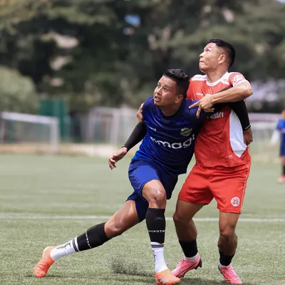 An intense aerial duel between two players, both committed to winning the header in a moment of peak action.