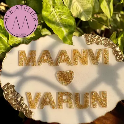 A close-up of the beautiful gold foil lettering on a white and gold geode nameplate for Maanvi and Varun. Every detail is crafted with so much pyar.