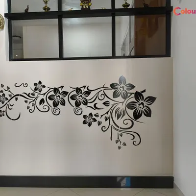A classic and elegant floral vine stencil in black, applied to a light-colored wall. This type of design works beautifully in hallways or living rooms to add a touch of sophisticated decoration.