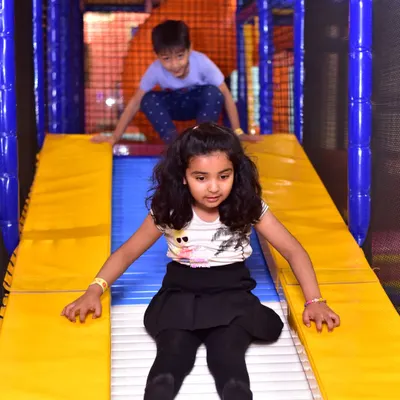 A young girl enjoys a fast ride down one of our roller slides. This slide provides a unique sensory experience with its rolling bars.