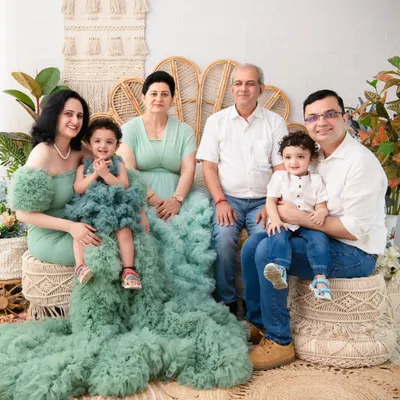 A beautiful portrait of three generations. This photo captures the entire family, including grandparents, in a coordinated and elegant setting, creating a priceless family heirloom.