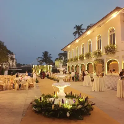 Here is a wide view of the Colaba Agiary courtyard, transformed for a beautiful Parsi union. The elegant architecture is enhanced with floral arrangements and strategic lighting, with a central fountain serving as a beautiful focal point.