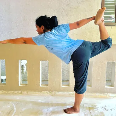 A student gracefully holding Natarajasana (Lord of the Dance Pose). This pose develops balance, flexibility in the spine, and strengthens the legs.