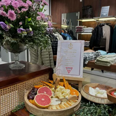 A stylish grazing platter set up for the Guess Autumn/Winter collection launch. The display is complemented by a custom menu and a beautiful floral arrangement, perfectly matching the brand's chic aesthetic.