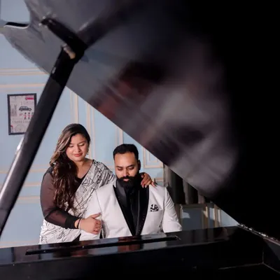 A beautifully framed shot of a couple by the grand piano in our elegant indoor set. This angle captures an intimate moment and highlights the classic European decor.