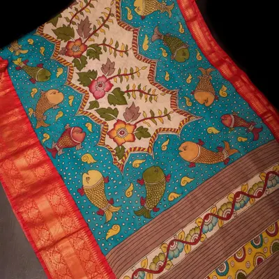 This Pen Kalamkari saree is a whimsical masterpiece, featuring hand-painted fish motifs swimming in a sea of blue. The central panel showcases intricate floral designs, all drawn by hand with natural dyes.