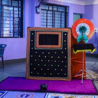 To keep the young guests entertained, we can organize activities like a magic show. Here is a magic show stage being set up before the performance begins at a first birthday party.
