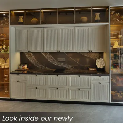 A full view of a timeless kitchen design, featuring classic white fluted cabinetry paired with a dramatic, veined marble backsplash. The glass-fronted upper cabinets with internal lighting add a touch of display elegance, creating a balanced and sophisticated look.