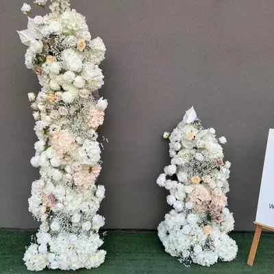 These tall, freestanding floral pillars are made with artificial white flowers and are ideal for high-impact event decor. I use them to frame stages, create grand entrances, or line wedding aisles.