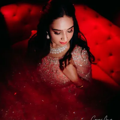 A dramatic, high-fashion shot of the bride's reception look. The focus is on her sparkling gown and the glamorous makeup, featuring a smokey eye and a bold red lip.