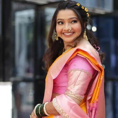 The quintessential Maharashtrian bride, looking radiant and happy. I created a fresh, minimal makeup look with a simple hairstyle to perfectly complement her beautiful pink and yellow Paithani saree.