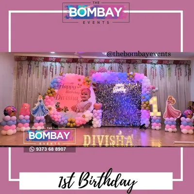 A dreamy first birthday for a little princess. This large-scale setup includes a personalized backdrop, a silver sequin wall, a pastel balloon arch, and cutouts of different Disney princesses.