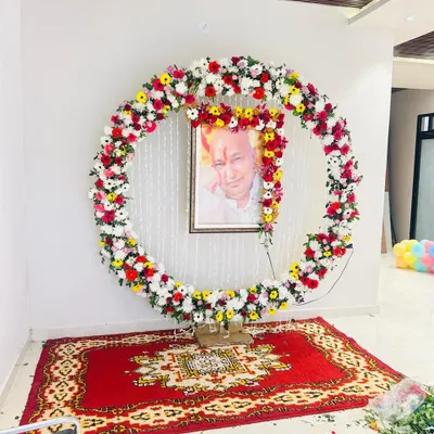 A floral frame we created for a Guruji Darbar at a client's home. The circular arrangement is made with fresh, colorful flowers like gerberas and chrysanthemums, providing a beautiful and respectful setting for the portrait.