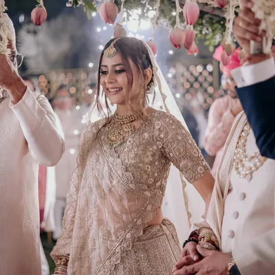 The bride's entry is a magical moment. Her soft, glowing makeup and elegant hairstyle are designed to look breathtaking as she walks towards her new beginning, framed by a beautiful floral canopy.
