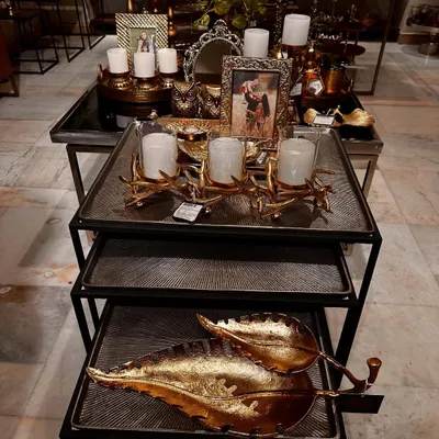 A beautiful display in my store featuring a mix of gold and silver decor, including candle holders, photo frames, and decorative leaf platters.