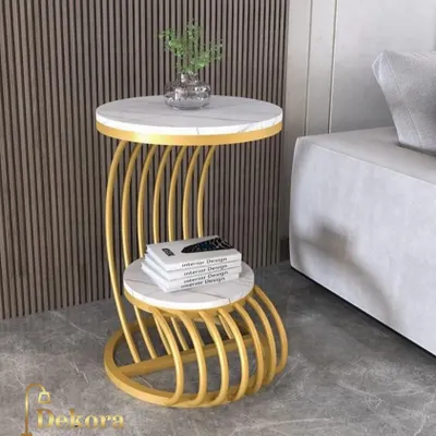 This C-shaped side table features a distinctive ribbed metal frame in a gold finish, supporting two marble-finish surfaces. Its tiered design is perfect for placing next to a sofa, providing convenient storage for books and decor.