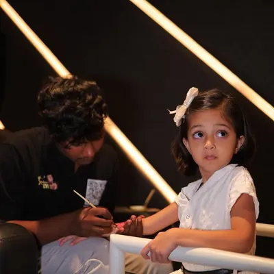 One of our talented artists carefully painting a temporary tattoo on a young guest's arm. We are professional and great with kids.