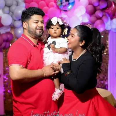 A happy family portrait at a first birthday party with a pink and white balloon backdrop. We ensure we get that perfect family shot you can cherish forever.