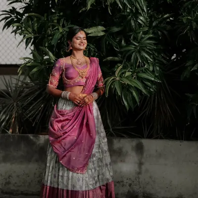A happy client looking beautiful in a grey and pink Langa Dhawani. This traditional South Indian outfit is a popular choice for coming-of-age ceremonies and engagement functions.