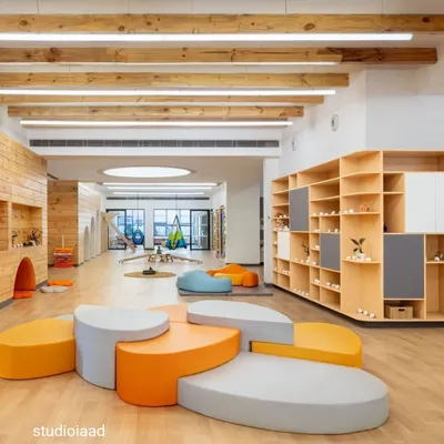 At the Heritage International School, we designed large, open activity centers to encourage unimpeded movement and exploration. The space features modular, pebble-like seating, natural wood finishes, and exposed ceiling beams, creating a warm, playful, and free-flowing learning environment.