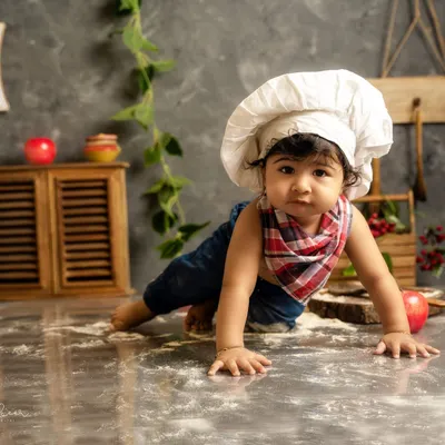 This little chef is on the move. A themed shoot is a great way to capture your baby's developmental milestones, like crawling, in a fun and creative way.