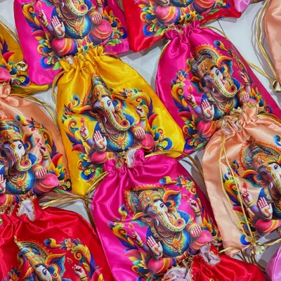 A vibrant collection of satin potli bags with colorful Ganpati prints. I made over 200 of these for a single order, and seeing them all together was such a milestone moment for my small business.