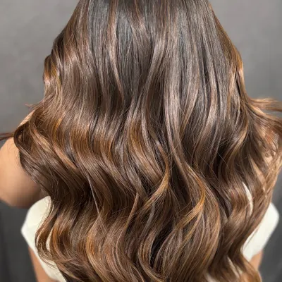 This is the caramel balayage dream. I created these flowing waves to show off the seamless blend of deep brown and warm caramel tones.