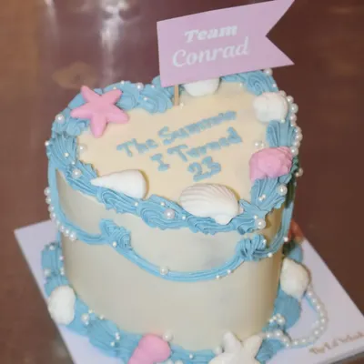 For the ones who never stopped rooting for Conrad. This "The Summer I Turned 23" cake is for you, complete with seashells, pearls, and a "Team Conrad" flag.