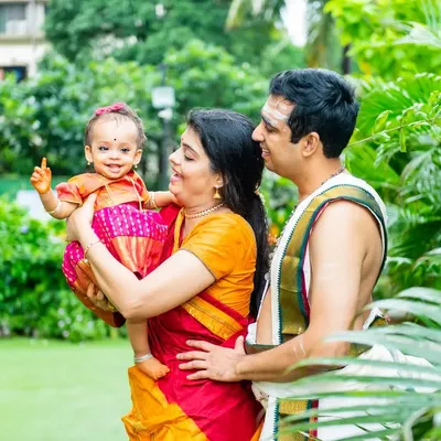 A beautiful family portrait from an Ayusha Homam ceremony, with the parents and baby dressed in traditional South Indian attire.