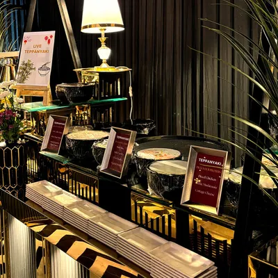 A wide view of our live Teppanyaki station, showcasing the sleek, modern setup and the professional appearance of our chefs and their workspace.