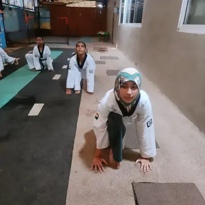 The warm-up is just as important as the training itself. Here, students get into a starting position for stretching, preparing their bodies for the intense workout ahead.
