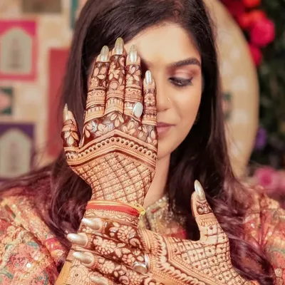 The final result: a happy bride with her stunning, dark-stained mehandi. This is a beautiful pose to capture the intricate details on the palm and fingers.
