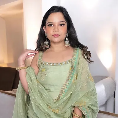 A beautiful example of a simple makeup look for a family function. The makeup is soft and elegant, with a focus on clean skin and defined eyes, perfectly complementing her pastel green suit.