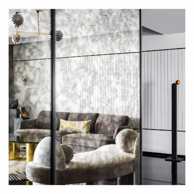 Reflections are a powerful tool in design. Here, an antique mirrored wall expands the living room of this seaside apartment, creating an illusion of depth while softly echoing the light and movement in the space. The effect is a luxurious, layered interior that feels both grand and intimate.