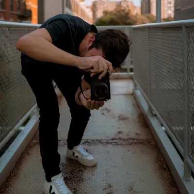 Me, lining up a shot on a walkway in New York City. Photography is my way of seeing and interacting with the world.