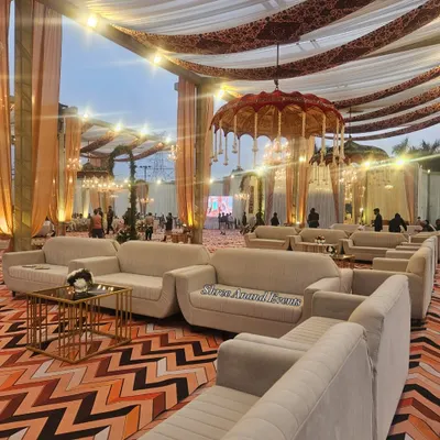 A wide view of the guest seating area, featuring comfortable sofas, elegant draping, and a traditional hanging umbrella as a centerpiece.