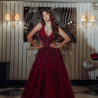 Ready for a night of glamour. This full length shot shows a stunning red gown, perfect for a Sangeet or reception. The makeup is bold and confident, designed to make a statement.